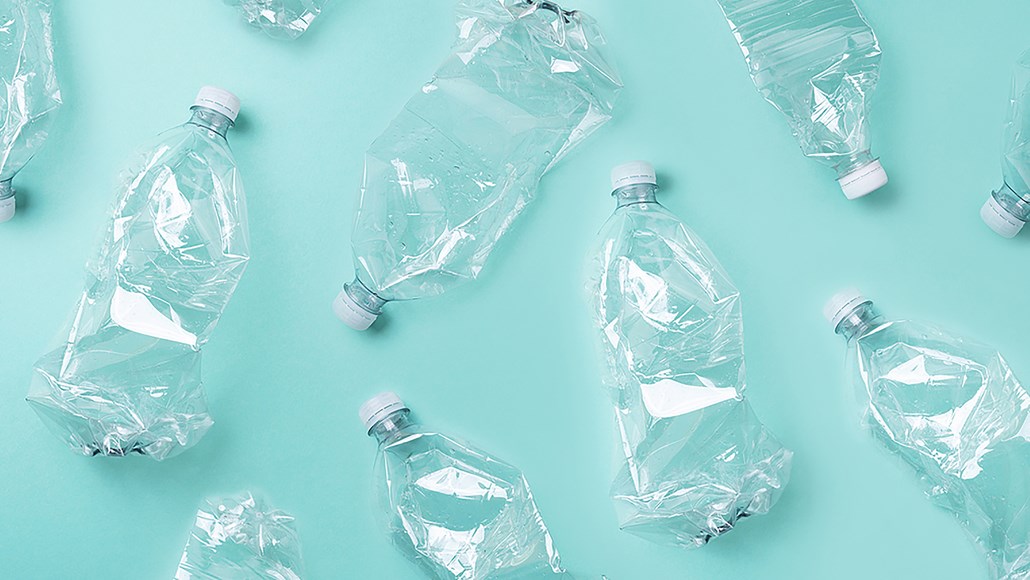 Photo of empty clear plastic bottles on turquoise background.